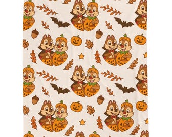 Puede incluir: Un patrón de Halloween con Chip y Chop sosteniendo calabazas. El diseño incluye calabazas, murciélagos, bellotas, hojas y estrellas en naranja, marrón y negro sobre un fondo crema. Adecuado para tela o decoración del hogar.