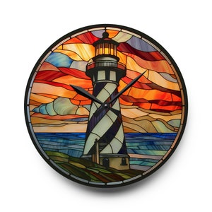 May include: A stained glass clock featuring a lighthouse with a black and white striped tower against a sunset sky with orange, red, and blue hues. The clock hands are black.
