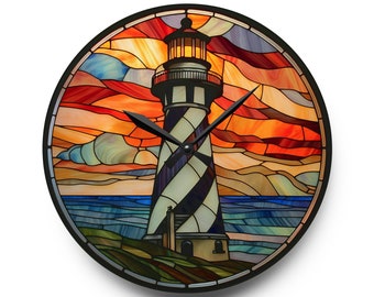 May include: A stained glass clock featuring a lighthouse with a black and white striped tower against a sunset sky with orange, red, and blue hues. The clock hands are black.