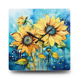 Puede incluir: Reloj de pared cuadrado con una pintura de acuarela de girasoles. La esfera del reloj tiene un fondo azul vibrante con detalles en amarillo y dorado. Los girasoles son amarillos con centros azules y manecillas negras.