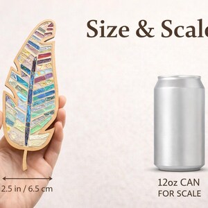 Op de afbeelding: Een houten veervormig moza&iuml;ekkunstwerk, 20 cm lang en 6,5 cm breed, met kleurrijke glazen stukken. De afbeelding bevat een 12oz blikje ter schaal en de tekst "Size & Scale".