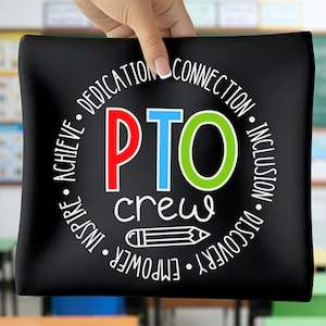 May include: Black rectangular pillow with the text "PTO crew" in white, red, blue, and green. The words "achieve, inspire, empower, discover, inclusion, connection, dedication" are in a circle around the text. A pencil graphic is below the word "crew".