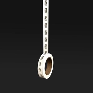 K&ouml;nnte beinhalten: Eine Rolle wei&szlig;es Klebeband mit dem Text "MMD", der sich wiederholt darauf befindet. Das Band befindet sich auf einem schwarzen Hintergrund.