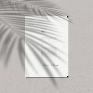 May include: A white letterhead with the name "Mari Adams" at the top, featuring a handwritten signature at the bottom. The paper is textured and has a shadow of a palm leaf across it. The background is a light gray.