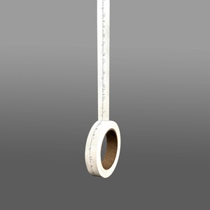 K&ouml;nnte beinhalten: Eine Rolle wei&szlig;es Washi-Klebeband mit schwarzem Text. Das Band h&auml;ngt von der Rolle, die aus braunem Karton besteht.