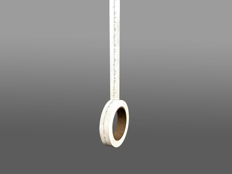 K&ouml;nnte beinhalten: Eine Rolle wei&szlig;es Washi-Klebeband mit schwarzem Text. Das Band h&auml;ngt von der Rolle, die aus braunem Karton besteht.