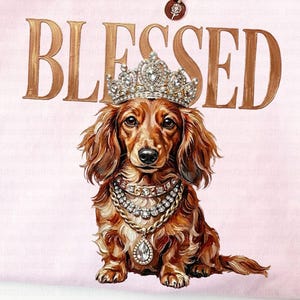 May include: A light pink t-shirt with the word "BLESSED" in gold lettering. The shirt features a dachshund wearing a crown and jewelry. A gold necklace with a pendant is also visible.