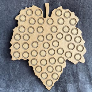 Champagne bottle cap display stand with vine leaves