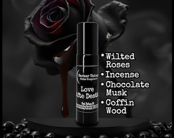 May include: A black rollerball perfume bottle labeled Darker Things Love Afte Death 10mL Perfume Oil, featuring a list of notes: Wilted Roses, Incense, Chocolate Musk, and Coffin Wood, set against a dark background with a black rose and skulls.