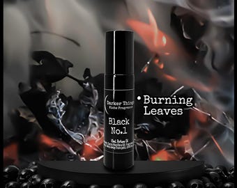 May include: A black perfume bottle labeled "Black No.1" with the text "Burning Leaves." The bottle is set against a backdrop of dark leaves and smoke, with a base of black skulls.