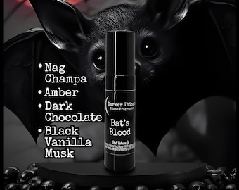 May include: A black perfume bottle labeled "Bat's Blood" with a bat illustration in the background. The bottle lists fragrance notes: Nag Champa, Amber, Dark Chocolate, Black Vanilla, and Musk. The background features a bat and skulls.