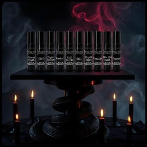 May include: Ten black cylindrical perfume oil roller bottles arranged in a row on a black pedestal. Each bottle features a label with the text Darker Things, the scent name, and Oil Perfume. The names include Stormy Night, Lilith, Night Terrors, Cemetery, Kill For Me, Hell, Liquid Night, Moonlight, Little Black Heart, and Haunted.