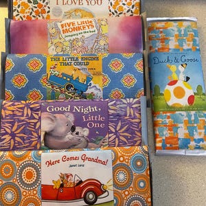 May include: A selection of children's books with vibrant covers. Titles include "Guess How Much I Love You," "Five Little Monkeys," "The Little Engine That Could," "Good Night, Little One," "Here Comes Grandma!," and "Duck & Goose."