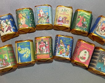 Könnte beinhalten: Eine Auswahl kleiner, rechteckiger Schokoriegel, verpackt in farbenfrohem Papier mit goldfarbenen Folienkanten. Jede Verpackung zeigt eine Vintage-Weihnachtsillustration und Text, darunter "Frosty", "Christmas Carols" und "Rudolph".