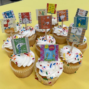 May include: A collection of cupcakes decorated with colorful sprinkles and topped with Dr. Seuss book character themed toppers. The toppers feature characters from books like "The Cat in the Hat", "Horton Hears a Who", "The Lorax", and "Yertle the Turtle".