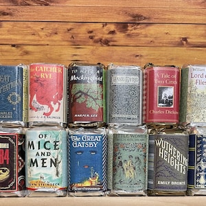 May include: A collection of 12 miniature book covers featuring classic novels. The covers are colorful and feature illustrations and text. The books include "Great Expectations", "The Catcher in the Rye", "To Kill a Mockingbird", "Jane Eyre", "A Tale of Two Cities", "Lord of the Flies", "1984", "Of Mice and Men", "The Great Gatsby", "Little Women", "Wuthering Heights", and "Pride and Prejudice".