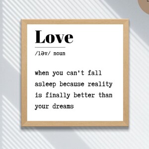 Może przedstawiać: Drukowana grafika ścienna z definicją słowa "love" w prostym czarnym foncie na białym tle. Definicja brzmi: "Love /lǝv/ noun when you can't fall asleep because reality is finally better than your dreams."