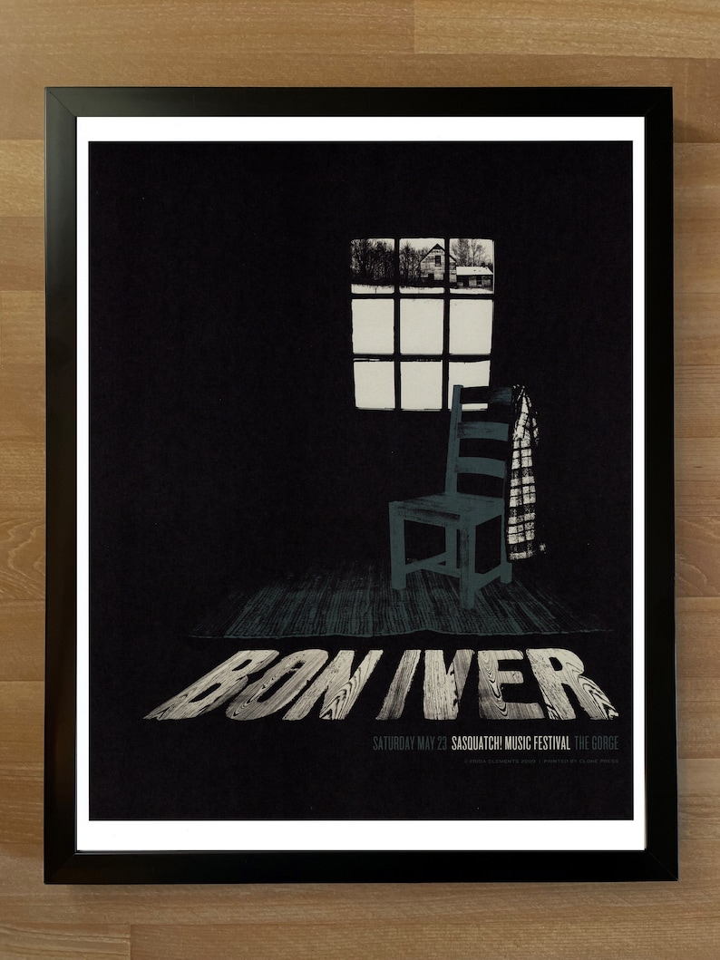 May include: A black and white poster with the text "Bon Iver" in large, stylized letters. The poster features a black and white image of a chair and a window with a view of a house in the distance. The text "Saturday May 23, Sasquatch! Music Festival, The Gorge" is printed at the bottom of the poster.
