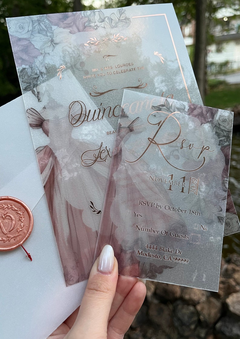 May include: A clear, floral-patterned RSVP card with rose gold lettering. The card includes the date "November 11, 2023", RSVP instructions, and a space for the number of guests. The address is "4444 Blake Dr Modesto, CA 99999".