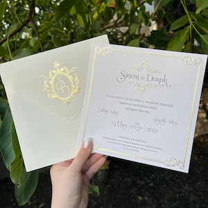 Hochzeitseinladung mit elfenbeinfarbenem Umschlag, goldgerahmte Einladung, goldenes Monogrammdesign, strukturierter Qualitätskarton