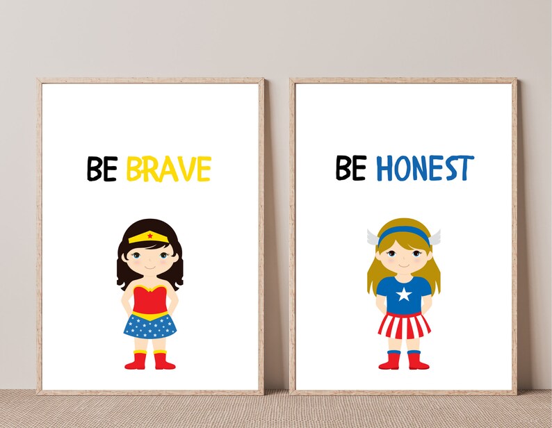 May include: Two framed art prints with cartoon illustrations of superhero girls. One print says "BE BRAVE" above a girl in a red and blue outfit. The other says "BE HONEST" above a girl in a blue and red outfit.