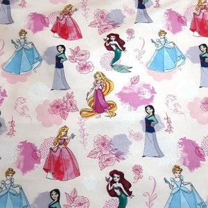 Może przedstawiać: R&oacute;żowy materiał z powtarzającym się wzorem księżniczek Disneya. Księżniczki to Kopciuszek, Ariel, Bella, Mulan, Rapunzel i Aurora. Materiał zawiera r&oacute;wnież r&oacute;żowe kwiaty i liście.