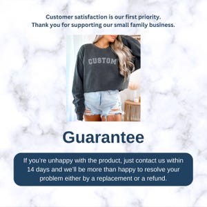 May include: A dark gray cropped sweatshirt with the word "CUSTOM" printed on the front. The sweatshirt is being worn by a person with long blonde hair and is paired with light blue denim shorts. The image has a white marble background with the text "Guarantee" and a message about a 14-day return policy.