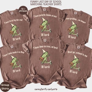 May include: Brown Comfort Colors t-shirts with various phrases for teachers on the last day of school. Each shirt features a cartoon frog riding a scooter, wearing a wizard hat and carrying a satchel. Phrases include "Twas pencils down at last" and "Hear ye, school is out."