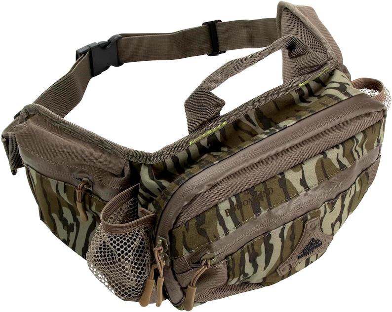 K&ouml;nnte beinhalten: Eine braune und tarnfarbene Bauchtasche mit mehreren Rei&szlig;verschlussf&auml;chern und einer Netztasche. Die Tasche hat einen schwarzen Schnallenverschluss und einen Griff. Der Text "Bottomland" ist auf der Vorderseite der Tasche zu sehen.