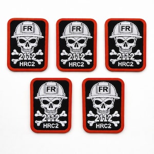 Puede incluir: Cinco parches negros y rojos con una calavera blanca con casco y huesos cruzados. Los parches tienen el texto "FR", "2112" y "HRC2". Los parches son rectangulares con un borde rojo.
