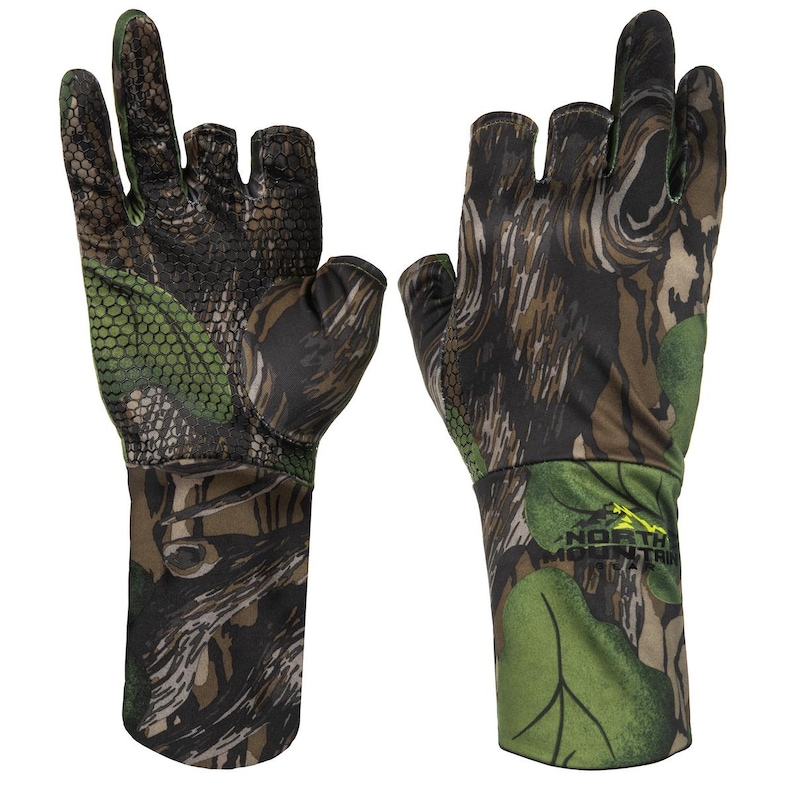 May include: Camouflage hunting gloves with open fingertips and thumb. The gloves have a green, brown, and black pattern. The words "NORTH MOUNTAIN" are printed on the wrist area. Designed for outdoor activities, these gloves are ideal for hunting.
