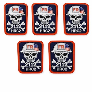 Puede incluir: Cinco parches azul marino con una calavera que lleva un casco blanco con un diseño de bandera estadounidense. Los parches tienen un borde naranja y el texto "FR", "2112" y "HRC2".