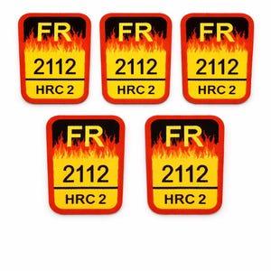 Puede incluir: Cinco parches rectangulares con fondo amarillo y borde rojo. Cada parche presenta las letras "FR" sobre el número "2112" y el texto "HRC 2", con un gráfico de llama en la parte superior.