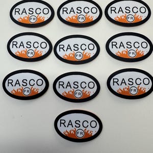 May include: A collection of ten oval-shaped patches. Each patch features the word "RASCO" in black, a flame design in orange and yellow, and the letters "FR" in a circle. The patches have a black border and a white background.