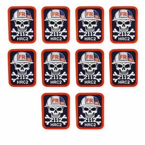 Puede incluir: Diez parches rectangulares con una calavera que lleva un casco blanco con un diseño de bandera americana. Cada parche tiene el texto "FR", "2112" y "HRC2". Los parches están delineados en rojo y tienen un fondo azul marino.