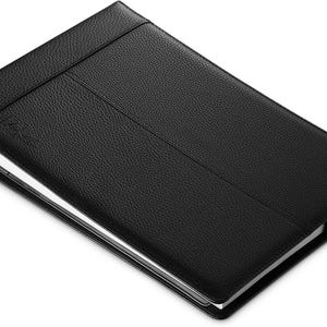 May include: Black leather notebook with a silver binder clip and a textured surface.