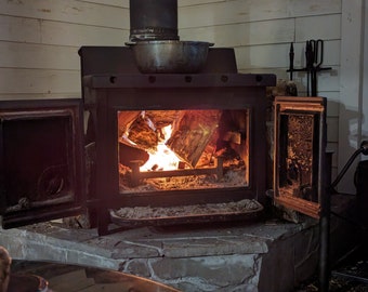 Wood stove log riser insert