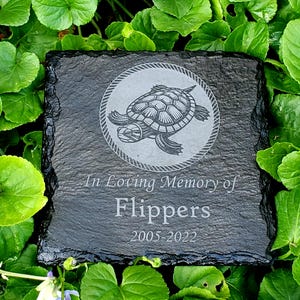 May include: Black slate memorial stone with a turtle graphic and the text "In Loving Memory of Flippers 2005-2022".