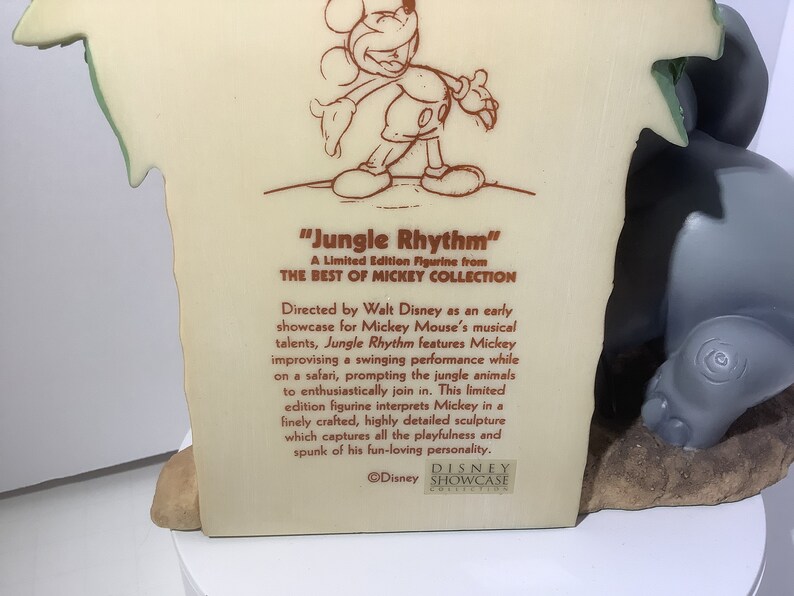 Puede incluir: Una figurita de color crema de Mickey Mouse tocando m&uacute;sica en un entorno de selva. La figurita forma parte de la "Best of Mickey Collection" y se titula "Jungle Rhythm".