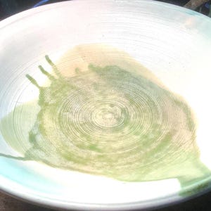 Handmade Pottery Bowl with artists signature, 7.5” round x 1deep. Colors: Turqoise, Olive, Dark Green, Cream, Light Brown