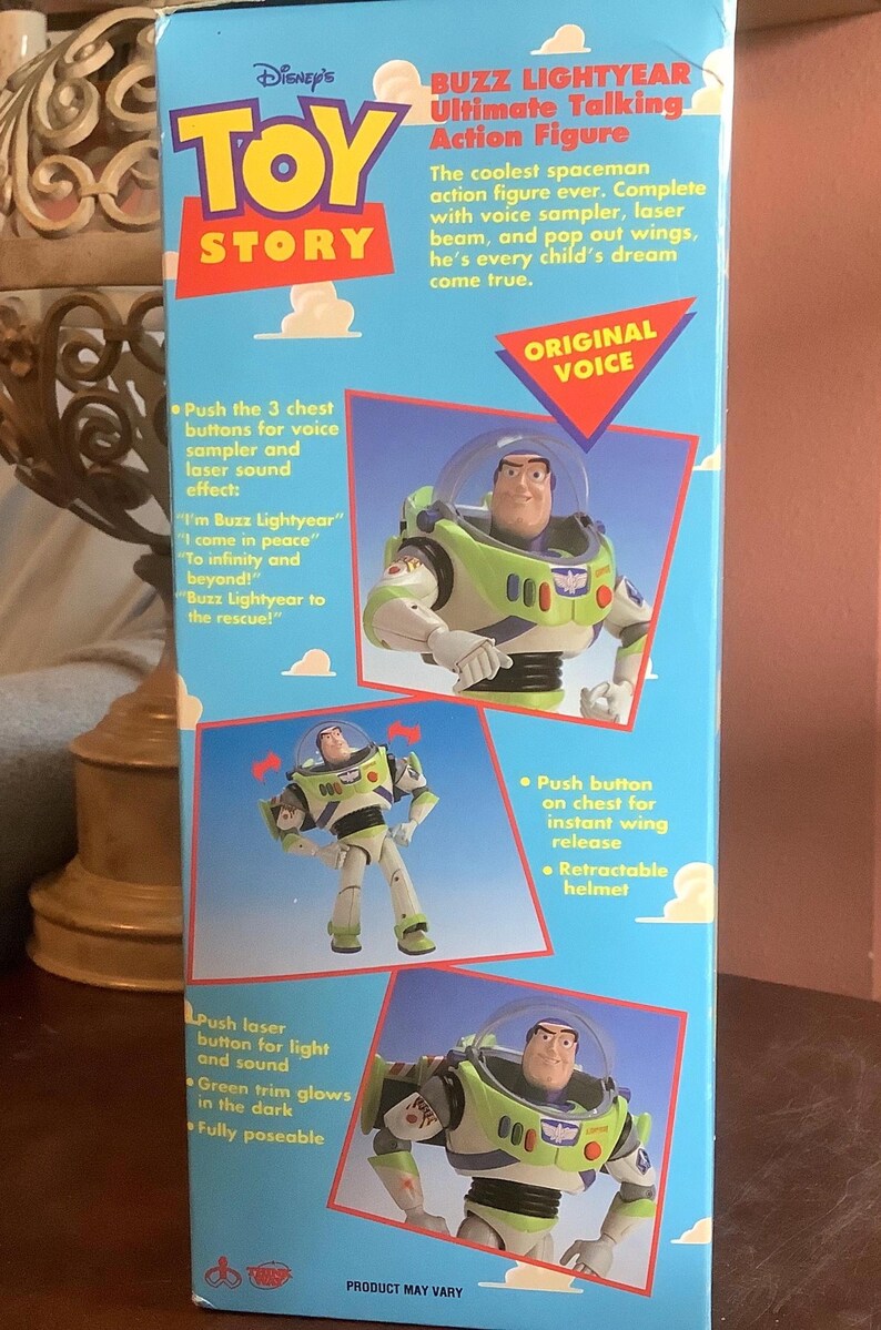 Op de afbeelding: Een doos voor een Buzz Lightyear Ultimate Talking Action Figure van Disney's Toy Story. De blauwe doos toont afbeeldingen van het speelgoed, met tekst over functies zoals een stem sampler en uitklapbare vleugels.