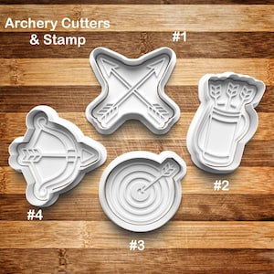 May include: White plastic cookie cutters in archery-themed shapes. The set includes a crossed arrows design, a quiver with arrows, a bow and arrow, and a target with an arrow. The text "Archery Cutters & Stamp" is at the top.