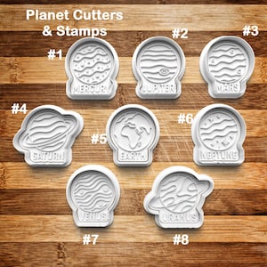 May include: A collection of white plastic planet-shaped cookie cutters and stamps. Each cutter is labeled with a planet name: Mercury, Jupiter, Mars, Saturn, Earth, Neptune, Venus, and Uranus. The text "Planet Cutters & Stamps" is at the top.