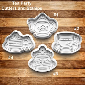 May include: White plastic cookie cutters and stamps in a tea party theme. The set includes a teapot, teacup, cake slice, and a tiered dessert stand. The text "Tea Party Cutters and Stamps" is at the top of the image.
