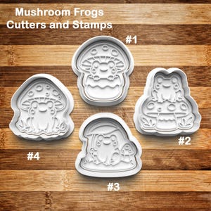 May include: Four white plastic cookie cutters and stamps in the shape of frogs on mushrooms. The text "Mushroom Frogs Cutters and Stamps" is at the top. Each cutter is numbered.