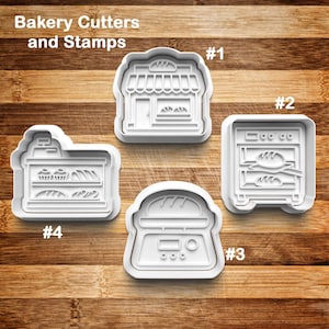 May include: Four white plastic cookie cutters and stamps on a wooden surface. The cutters are shaped like a bakery, oven, scale, and display case. The text "Bakery Cutters and Stamps" is at the top.