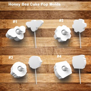 May include: White Honey Bee Cake Pop Molds in various shapes, including a bee, cloud, and flower. Each mold is attached to a white stick. The text "Honey Bee Cake Pop Molds" is at the top of the image.