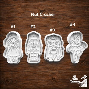 May include: Four white plastic cookie cutters labeled Nut Cracker with numbers 1 through 4. The shapes include a girl holding a nutcracker, a soldier nutcracker, a mouse king with a staff, and a ballerina in a tutu, all with detailed outlines.