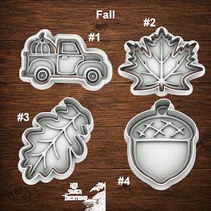 May include: Four white plastic cookie cutters labeled #1 through #4. #1 is a truck with a pumpkin, #2 is a maple leaf, #3 is an oak leaf, and #4 is an acorn. The text Fall is at the top, and the logo HB Shack Creations is at the bottom.
