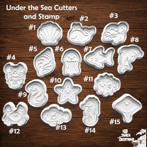 May include: A collection of white plastic Under the Sea Cutters and Stamp tools labeled 1 through 15, featuring shapes of a seashell, whale, turtle, lobster, conch, jellyfish, shark, dolphin, eel, starfish, pufferfish, crab, fish, seahorse, and stingray.